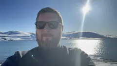 Gary beside the snow-covered Arctic fjord