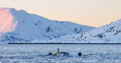 Kayak rolling beneath the snowy mountains