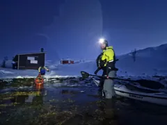 Landing the kayaks on the snowy shore at night