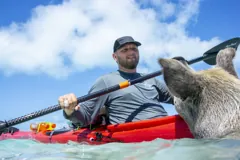 Gary with his paddle beside a swimming pig