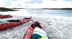 Expedition kayaks on a white-sand beach in the Bahamas